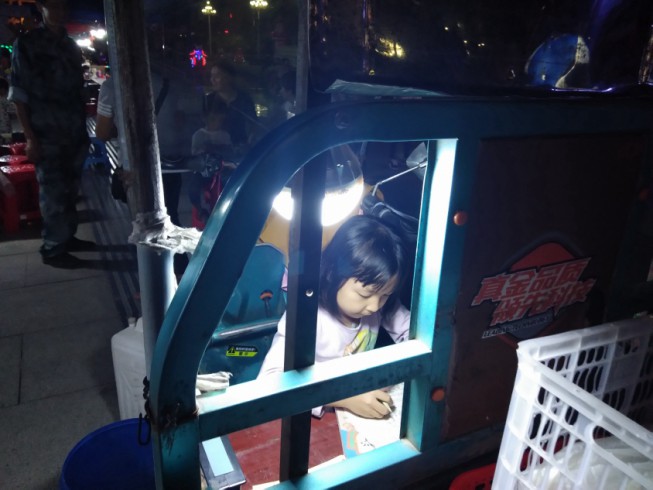 江西遂川：广场夜晚现一女孩在车椅上做作业 爱学习画面感人